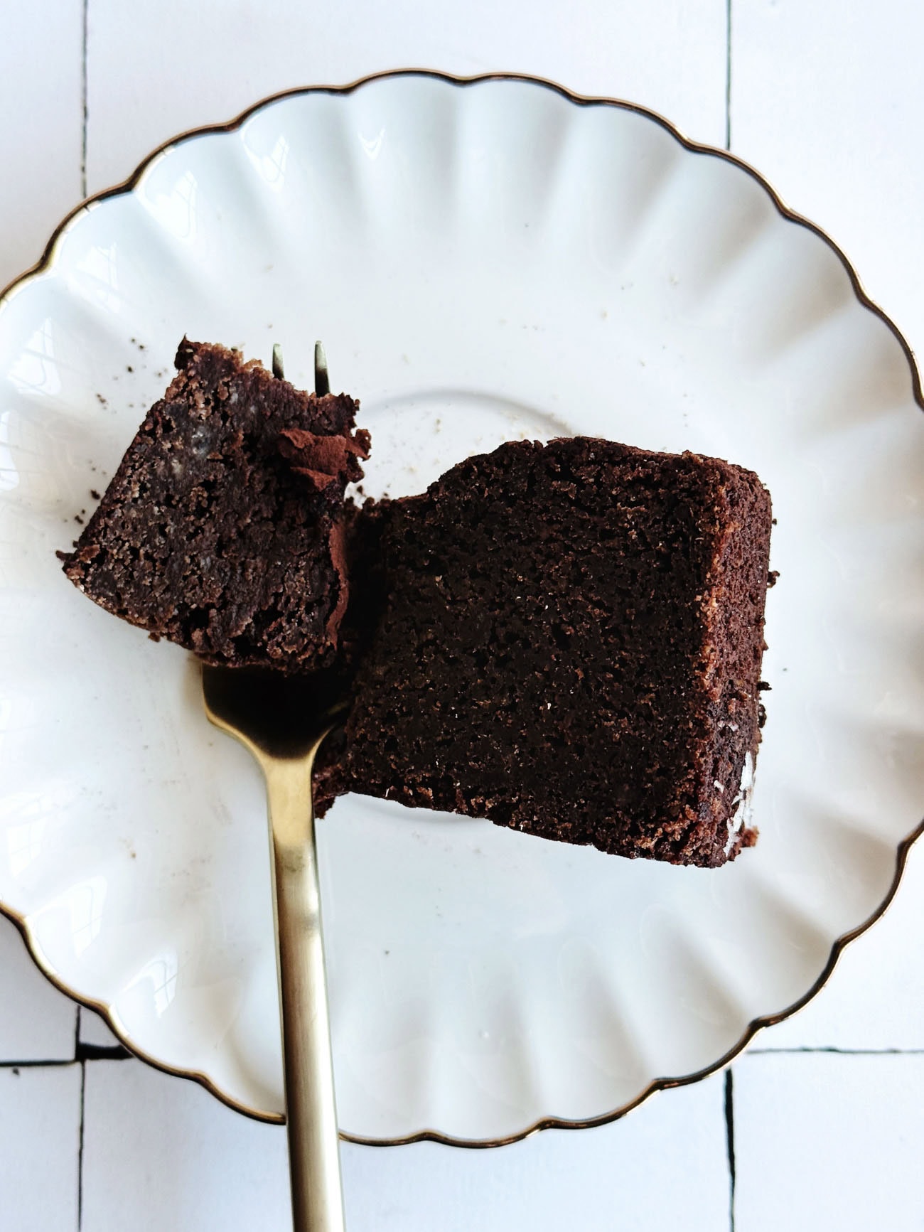 chocolate cake on white plate with gold fork